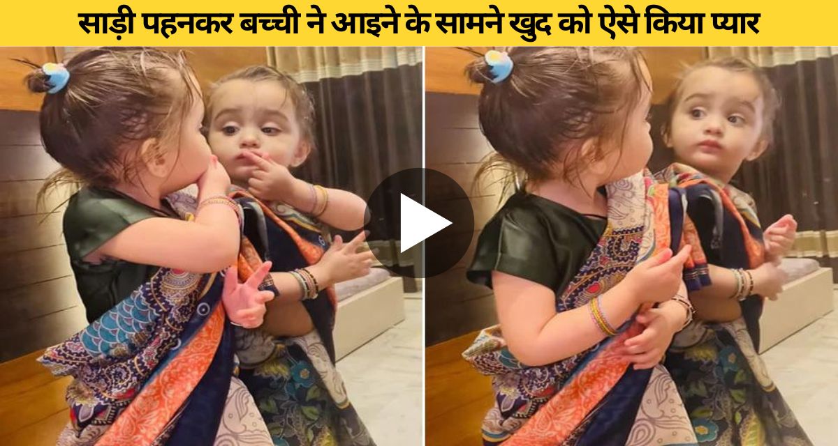 A cute expression of a girl child seeing herself in a sari in the mirror